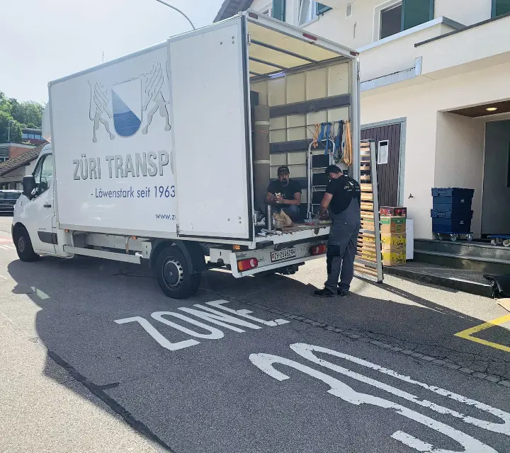 Umzugswagen von Züri Transport beim Verladen an der Rampe eines Verwaltungsgebäudes