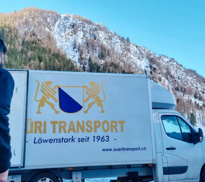 Mitarbeiter von Züri Transport beim Umzugswagen im verschneiten Bergland