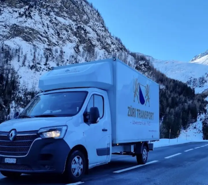 Umzugswagen von Züri Transport auf einer verschneiten Alpenstrasse