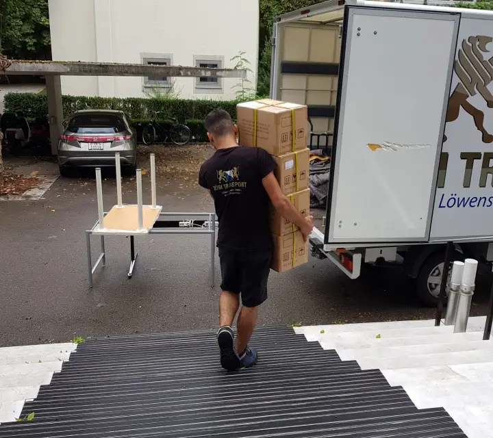 Zügelmann trägt Möbel über ausgelegten Bodenschutz